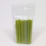 A clear plastic bag containing a bunch of green celery sticks.