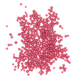 numerous small, round, and shiny pink beads scattered across a white background.