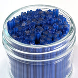 A glass jar filled with blue and black objects, possibly resembling a collection of small, cylindrical objects.