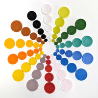 Set of colorful Powder Wafer Circles made from fusible COE 96 glass arranged in a circular pattern on a white background