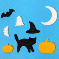 Halloween-themed cutouts including a black cat, pumpkins, bats, ghosts, and a witch's hat on a blue background.