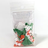 Packaged Christmas-themed fusible glass powder wafers on a white background.