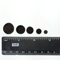 One powder wafer in each of the five sizes with a ruler for scale comparison.