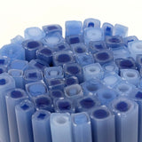 a close-up view of numerous blue and white cylindrical objects, possibly made of glass or plastic, arranged in a circular pattern.