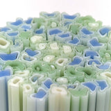 The image is a close-up of a collection of colorful, abstract shapes resembling flowers or leaves, with varying shades of blue, green, and white.