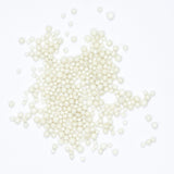 numerous small, white beads scattered across a white background.