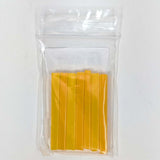 A clear plastic bag containing a stack of yellow plastic sticks.