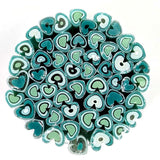 a circular arrangement of various shades of green and blue glass tubes or rods, creating a visually striking and intricate design.