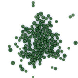 a large number of small, round green beads or spheres scattered across a white background.