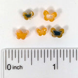 a collection of small, colorful beads arranged on a ruler for size comparison.