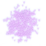 numerous small, round, and shiny purple beads scattered across a white background.