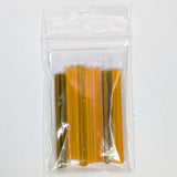 A clear plastic bag containing several yellow and orange objects, which appear to be small, cylindrical or tube-like in shape.