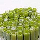 a close-up view of a collection of green and white objects, possibly candies or sweets, arranged in a circular pattern.
