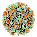 The image is a circular arrangement of colorful glass beads or marbles, featuring a variety of shapes and colors including shades of green, orange, and white.