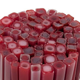 a close-up view of numerous red and pink candles or sticks arranged in a circular pattern.