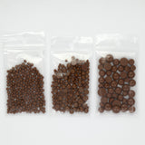 Three transparent plastic bags filled with chocolate balls are arranged in a row.