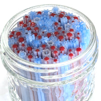 A glass jar filled with colorful, multicolored straws in shades of blue and red.