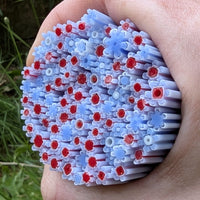 A hand is holding a large cluster of colorful plastic straws, with red and blue plastic pieces interspersed throughout the cluster.