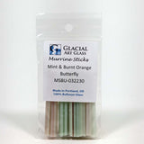 A package of Glacial Art Glass Murrine Sticks, which are mint and burnt orange colored, made in Portland, Oregon, and 100% Bullseye glass.