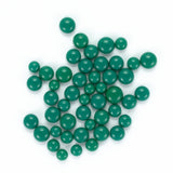 a collection of green beads or stones, scattered and overlapping each other on a white background.