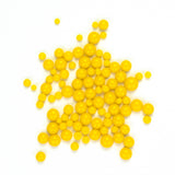 numerous small, round, yellow balls scattered across a white background.