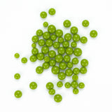 a collection of green, round objects scattered on a white background.