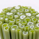 a close-up view of numerous green and white cylindrical objects, resembling a cluster of bananas or similar fruits.