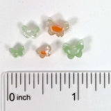 a collection of small, colorful beads arranged on a ruler for size comparison.